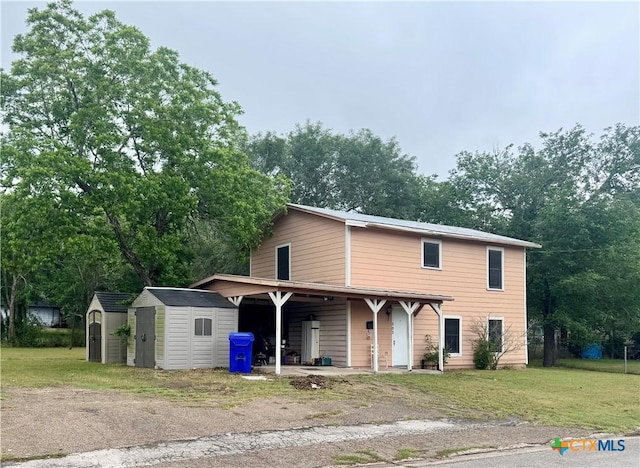503 Dunn St, Yoakum, TX 77995 - traditional home with aphalt driveway, a front yard, a shed, and an outbuilding