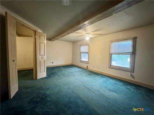 503 Dunn St, Yoakum, TX 77995 - unfurnished bedroom with ceiling fan, beam ceiling, dark colored carpet, and baseboards