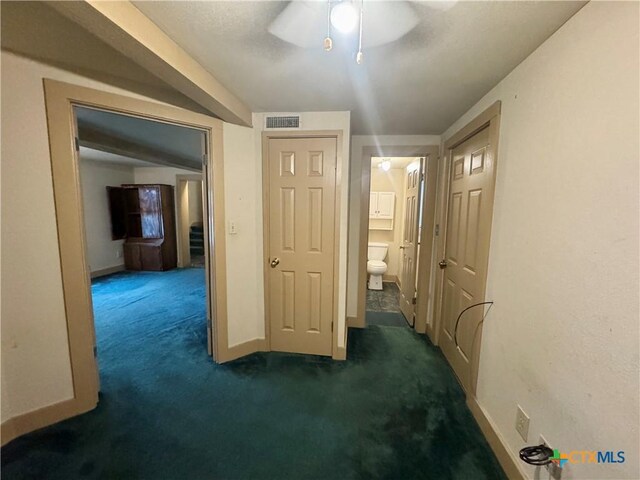 503 Dunn St, Yoakum, TX 77995 - corridor with dark carpet, visible vents, and baseboards