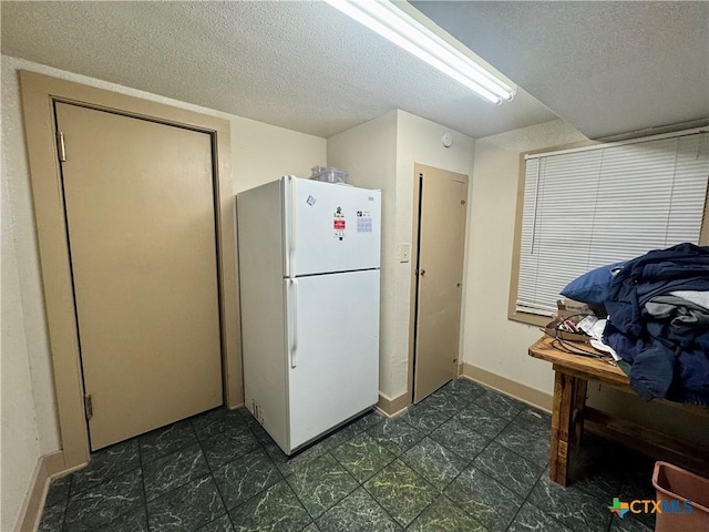 503 Dunn St, Yoakum, TX 77995 - kitchen featuring baseboards, a textured ceiling, and freestanding refrigerator
