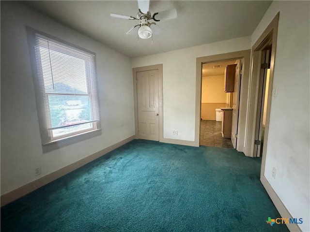 503 Dunn St, Yoakum, TX 77995 - unfurnished bedroom featuring dark colored carpet, a ceiling fan, and baseboards