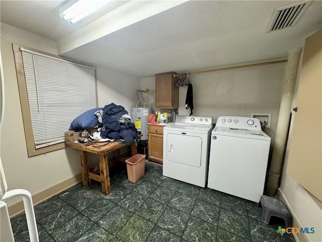 503 Dunn St, Yoakum, TX 77995 - laundry area with visible vents, baseboards, electric water heater, separate washer and dryer, and cabinet space
