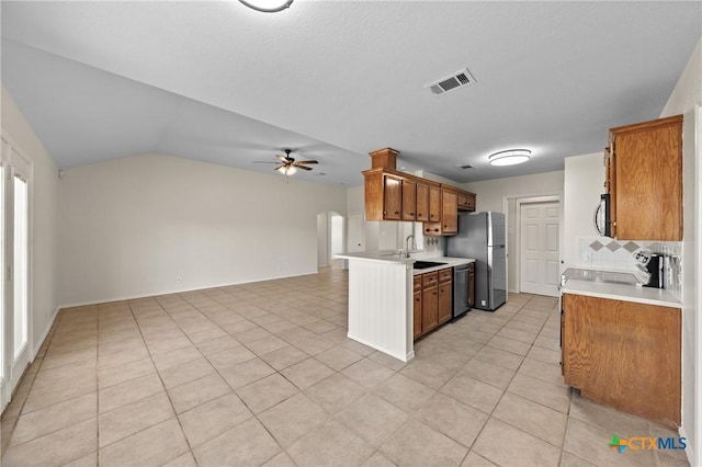 kitchen featuring sink, appliances with stainless steel finishes, kitchen peninsula, ceiling fan, and decorative backsplash