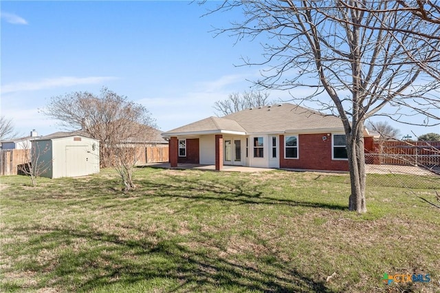 rear view of property featuring a storage unit, a patio area, and a lawn