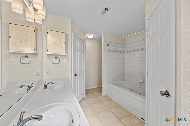 bathroom featuring vanity, tile patterned flooring, and tiled shower / bath