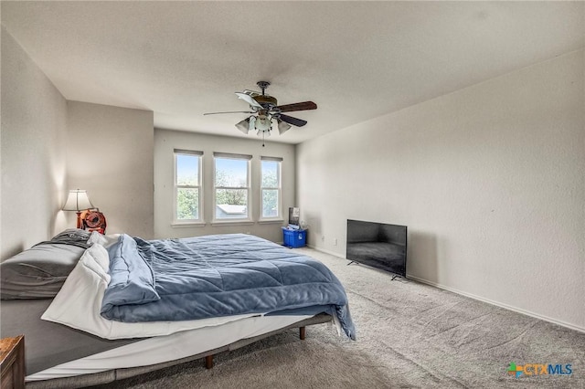 carpeted bedroom featuring ceiling fan and baseboards