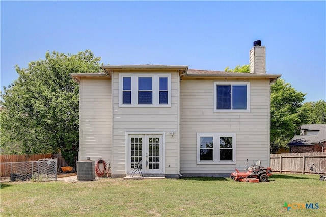 rear view of property featuring central AC, a chimney, french doors, fence, and a yard