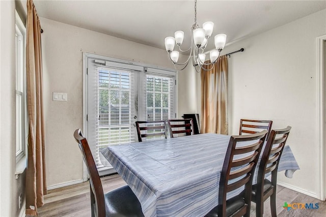 dining area with wood finished floors, baseboards, and a chandelier