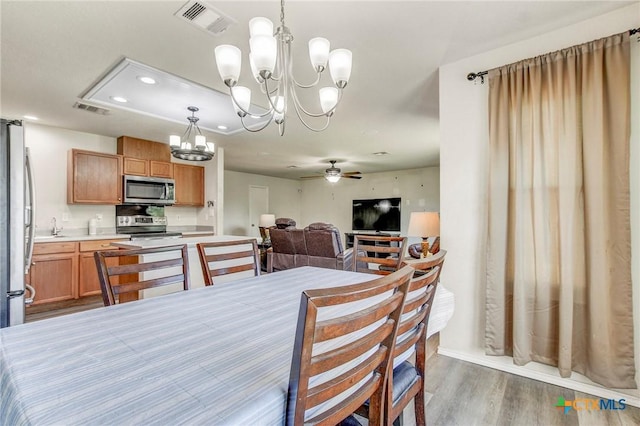 dining area with recessed lighting, wood finished floors, visible vents, and ceiling fan with notable chandelier