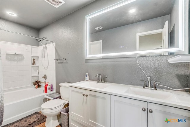 bathroom featuring toilet, a textured wall, a sink, and visible vents