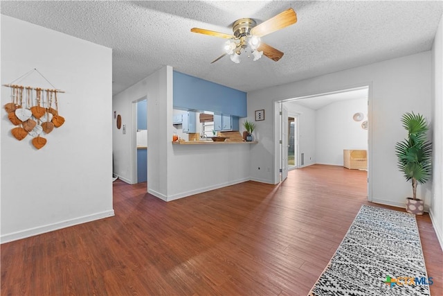 living area with baseboards, wood finished floors, a textured ceiling, and ceiling fan