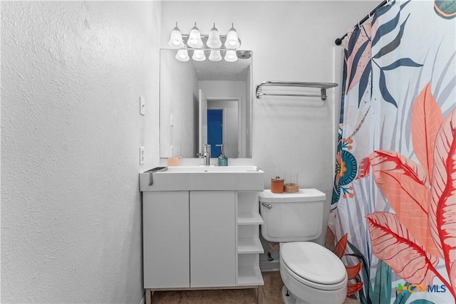 full bathroom with toilet, vanity, a shower with curtain, and a textured wall