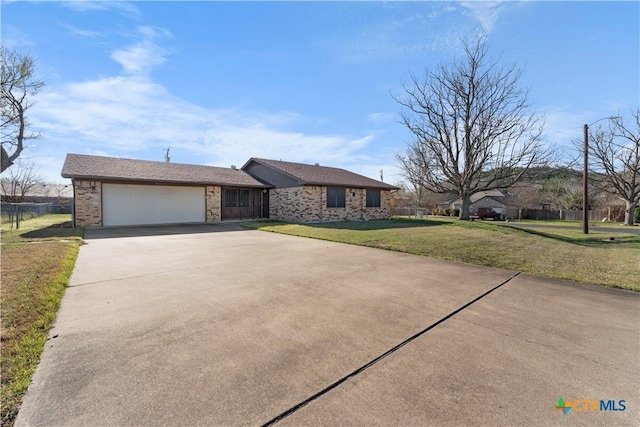 view of front of home featuring a front yard, concrete driveway, brick siding, and an attached garage