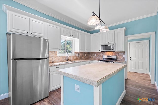 2212 Clay Ave, Waco, TX 76706 - kitchen featuring appliances with stainless steel finishes, a sink, light countertops, ornamental molding, and backsplash