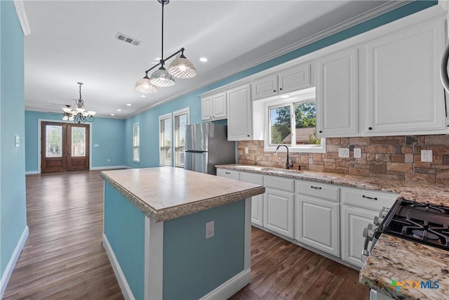 2212 Clay Ave, Waco, TX 76706 - kitchen with freestanding refrigerator, a chandelier, ornamental molding, baseboards, and dark wood-style flooring