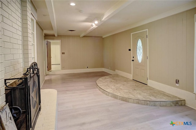 1705 Neuman St, Gonzales, TX 78629 - foyer entrance featuring light wood-style floors, beamed ceiling, a fireplace, and wooden walls