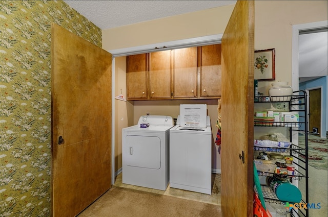 washroom with light colored carpet, cabinets, a textured ceiling, and independent washer and dryer