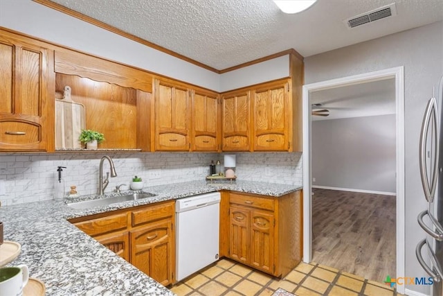 kitchen with white dishwasher, a sink, a textured ceiling, decorative backsplash, and ceiling fan