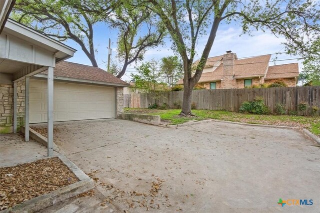 view of yard featuring fence and driveway