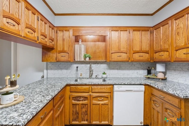 kitchen featuring white dishwasher, a sink, brown cabinetry, decorative backsplash, and light stone counters