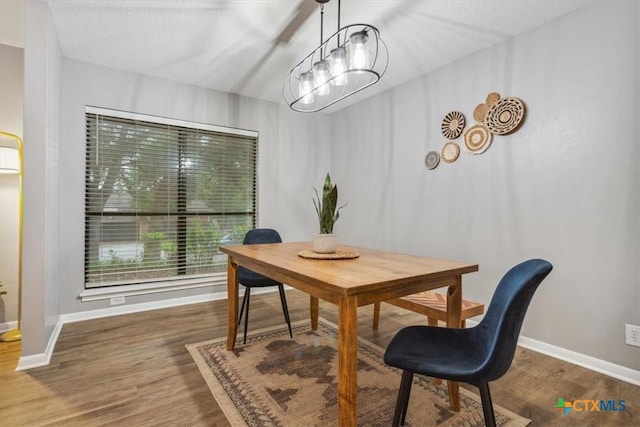 dining space featuring wood finished floors and baseboards
