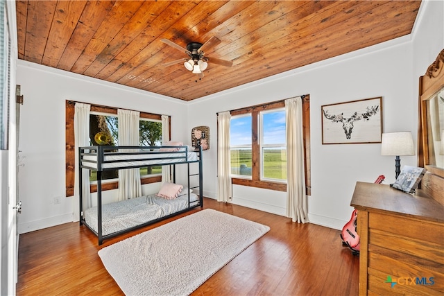 bedroom featuring wood-type flooring, multiple windows, and wooden ceiling