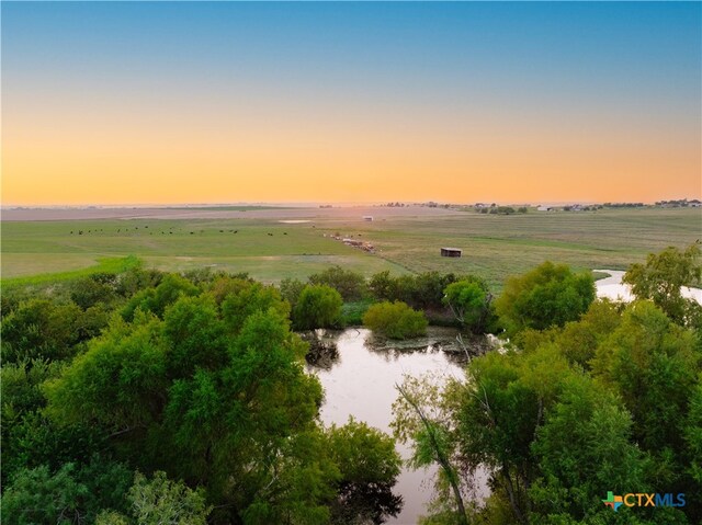 aerial view at dusk with a rural view and a water view