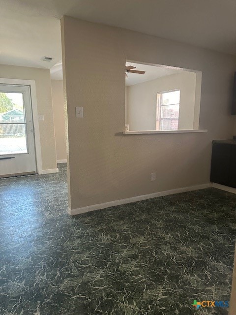 unfurnished room with a wealth of natural light and ceiling fan