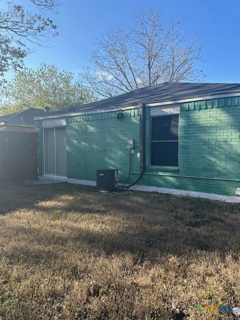 rear view of property with a yard and central AC