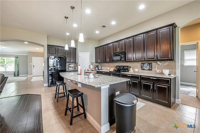 822 Old World Dr, Harker Heights, TX 76548 - kitchen with black appliances, arched walkways, backsplash, recessed lighting, and a kitchen bar