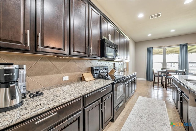 822 Old World Dr, Harker Heights, TX 76548 - kitchen with black appliances, decorative backsplash, light stone countertops, dark brown cabinetry, and recessed lighting