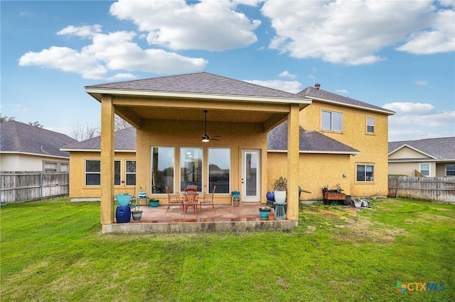 back of property with a patio, a yard, and ceiling fan