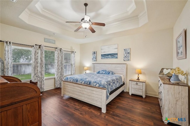 bedroom featuring crown molding, a tray ceiling, dark wood-type flooring, and ceiling fan