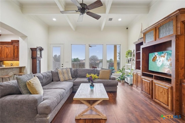 living room featuring beam ceiling, a high ceiling, dark wood-type flooring, ceiling fan, and coffered ceiling