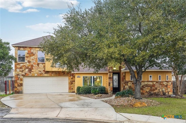 view of front of home with a garage, stone siding, and fence