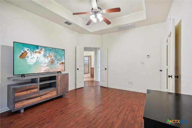 living room featuring a tray ceiling, ceiling fan, dark hardwood / wood-style flooring, and crown molding