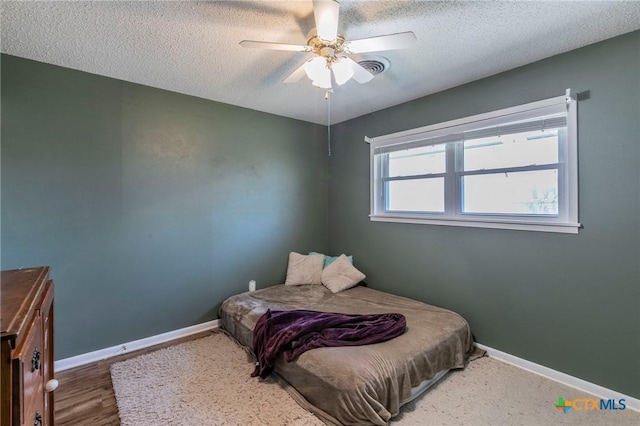 bedroom with ceiling fan and a textured ceiling