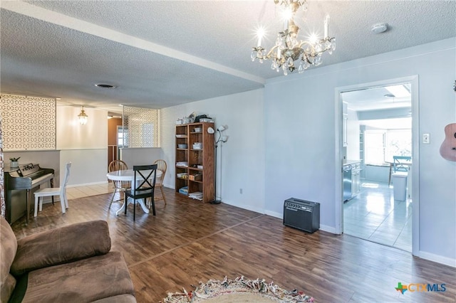 living room featuring a notable chandelier, hardwood / wood-style flooring, and a textured ceiling