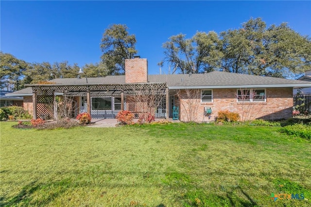 rear view of property with a lawn