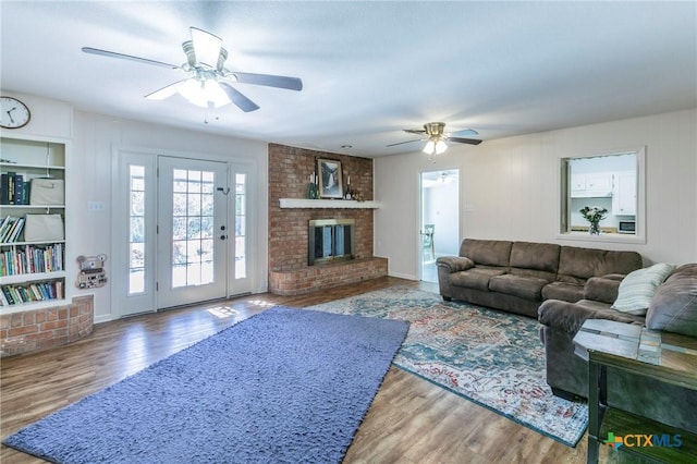 living room featuring ceiling fan, a fireplace, and hardwood / wood-style floors