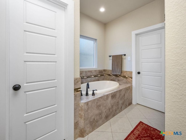 full bath featuring a bath and tile patterned floors