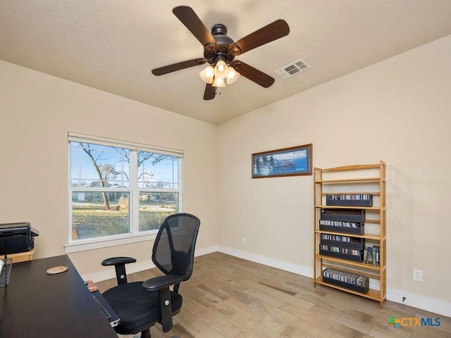 home office with light wood-style floors, baseboards, visible vents, and ceiling fan