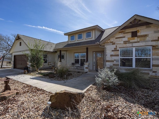 view of front of property with stone siding, driveway, and an attached garage