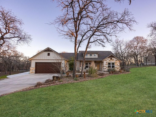 view of front of property with a garage, driveway, stone siding, board and batten siding, and a front yard