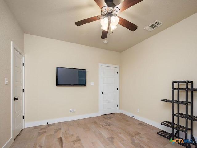 empty room with light wood-style flooring, visible vents, and baseboards