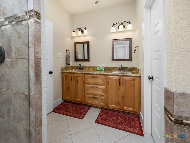 full bathroom featuring double vanity, visible vents, a sink, and tile patterned floors