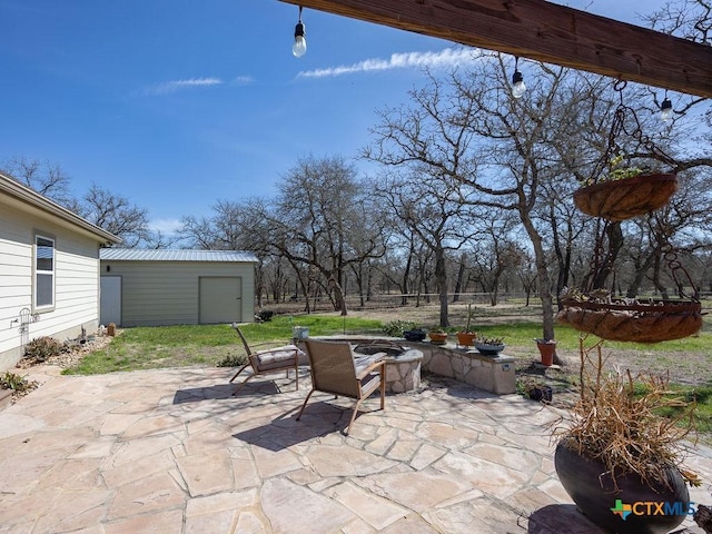 view of patio featuring an outbuilding and a fire pit