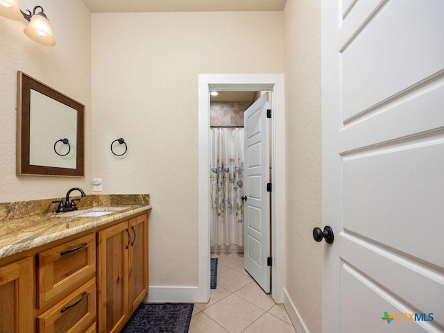 full bathroom featuring curtained shower, vanity, baseboards, and tile patterned floors