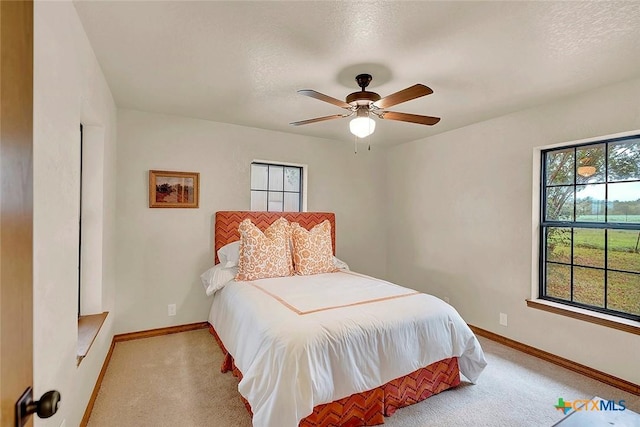 carpeted bedroom with baseboards and ceiling fan