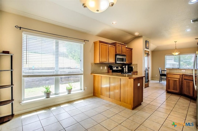 2406 Peace Pipe Cir, Copperas Cove, TX 76522 - kitchen featuring stove, stainless steel microwave, vaulted ceiling, a peninsula, and brown cabinets